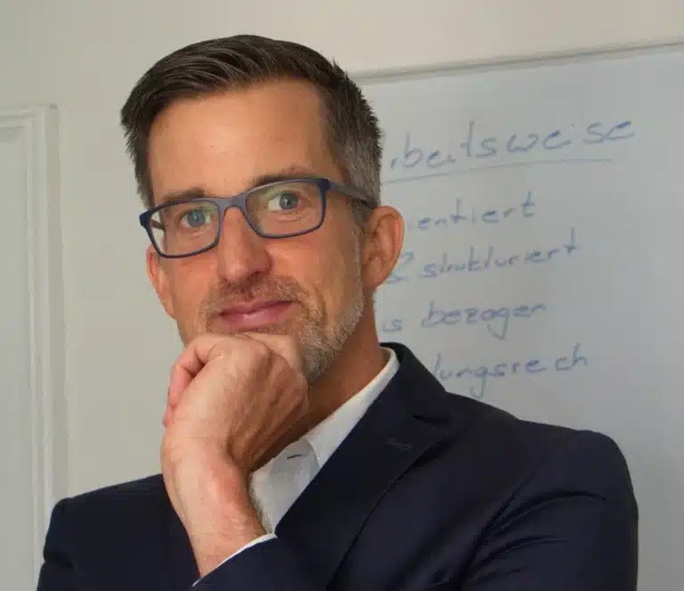 Oliver Kober vor einem Flipchart mit Notizen zur wirksamen Zusammenarbeit – Business-Trainer & Coach